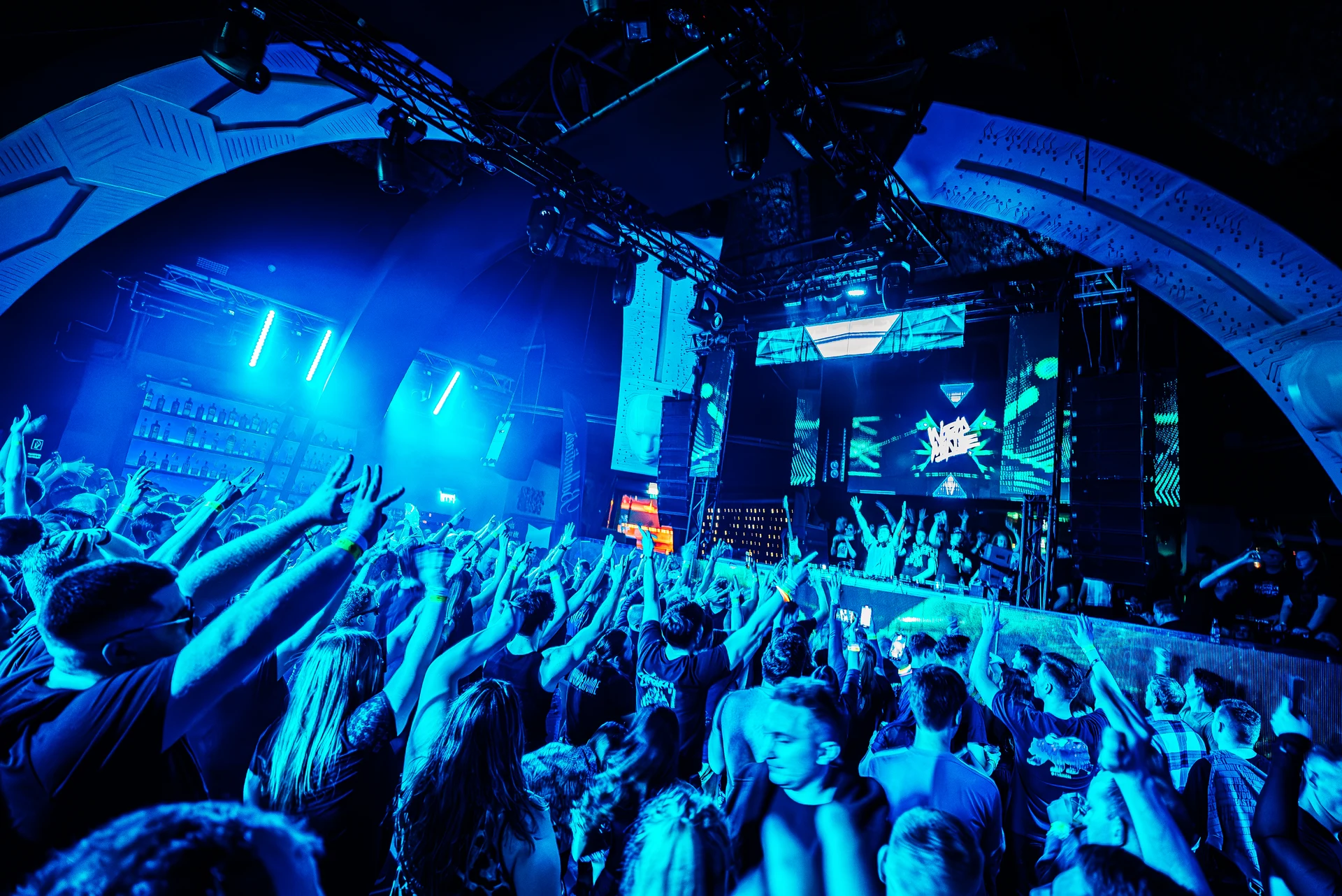 Subrage performing above a blue-lit club crowd